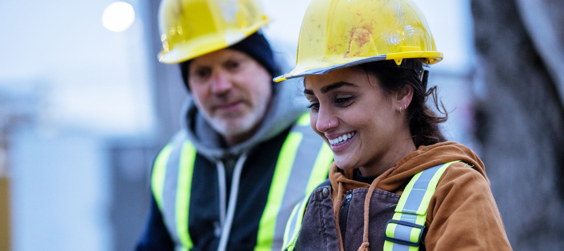 Female Construction Worker Talks With A Co Worker At A Site