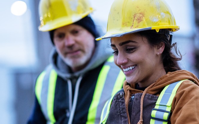 Female Construction Worker Talks With A Co Worker At A Site