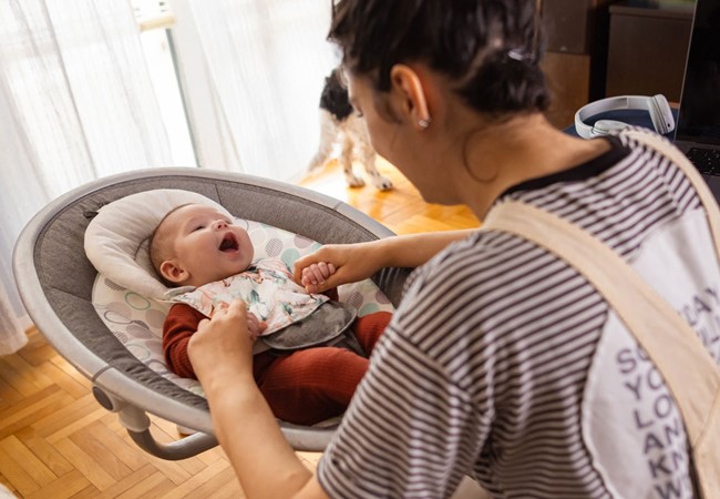 Female Babysitter Watching A Baby At Home