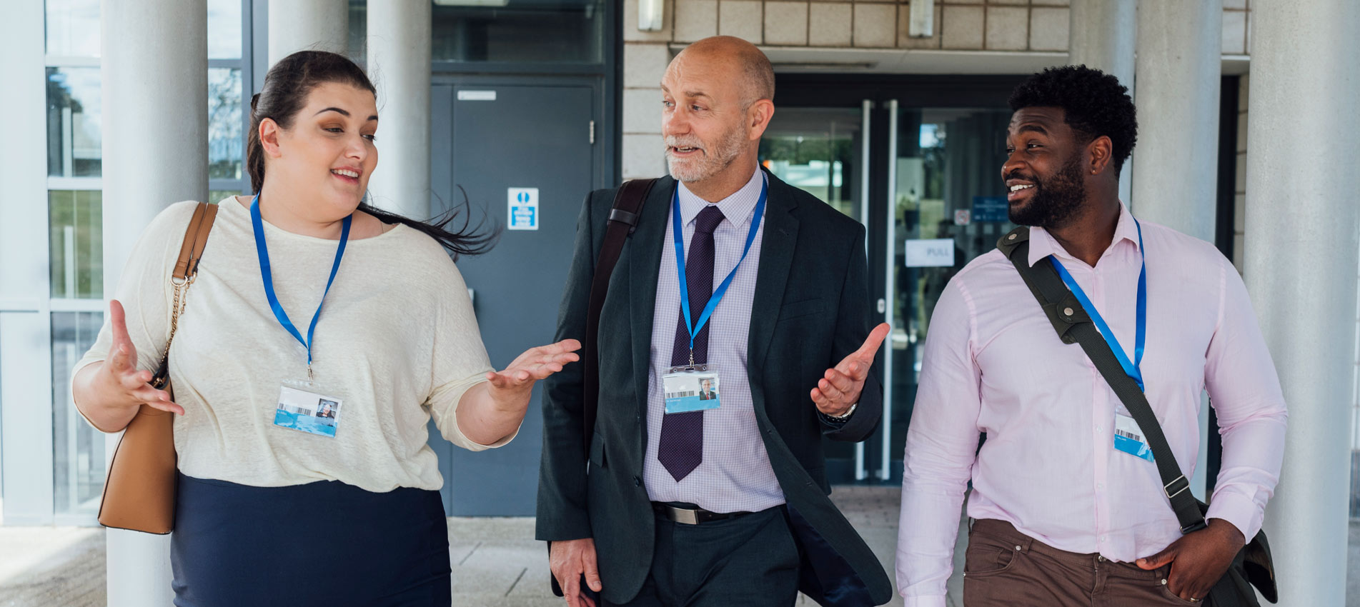 Three Teachers Talking To Each Other While Walking Away From The Building