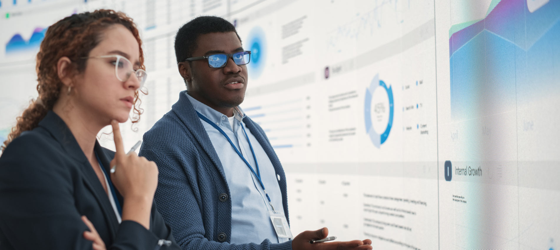 Two Colleagues Analyzing Data On Screen