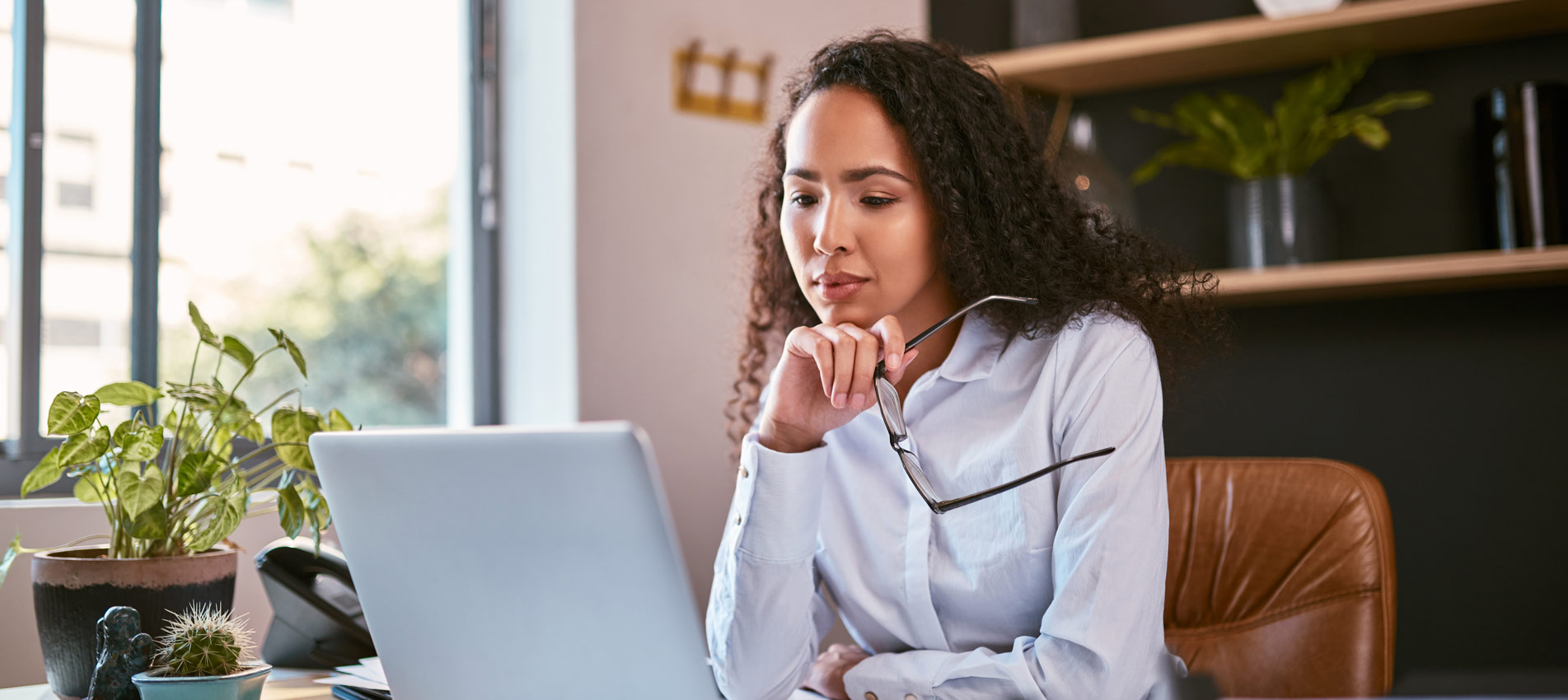 Hispanic Business Woman Using Laptop Reading And Thinking