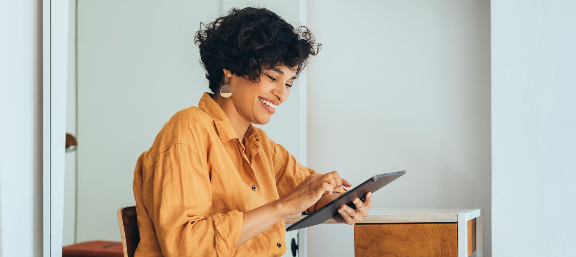 An Entrepreneur In Her Office Reading Something On Her Tablet