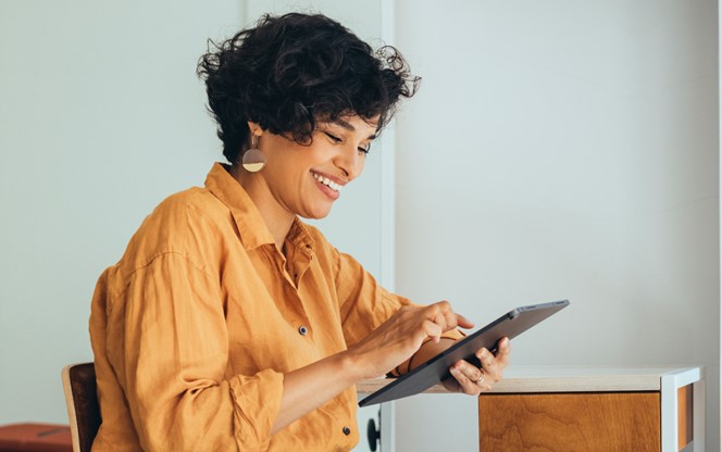 An Entrepreneur In Her Office Reading Something On Her Tablet