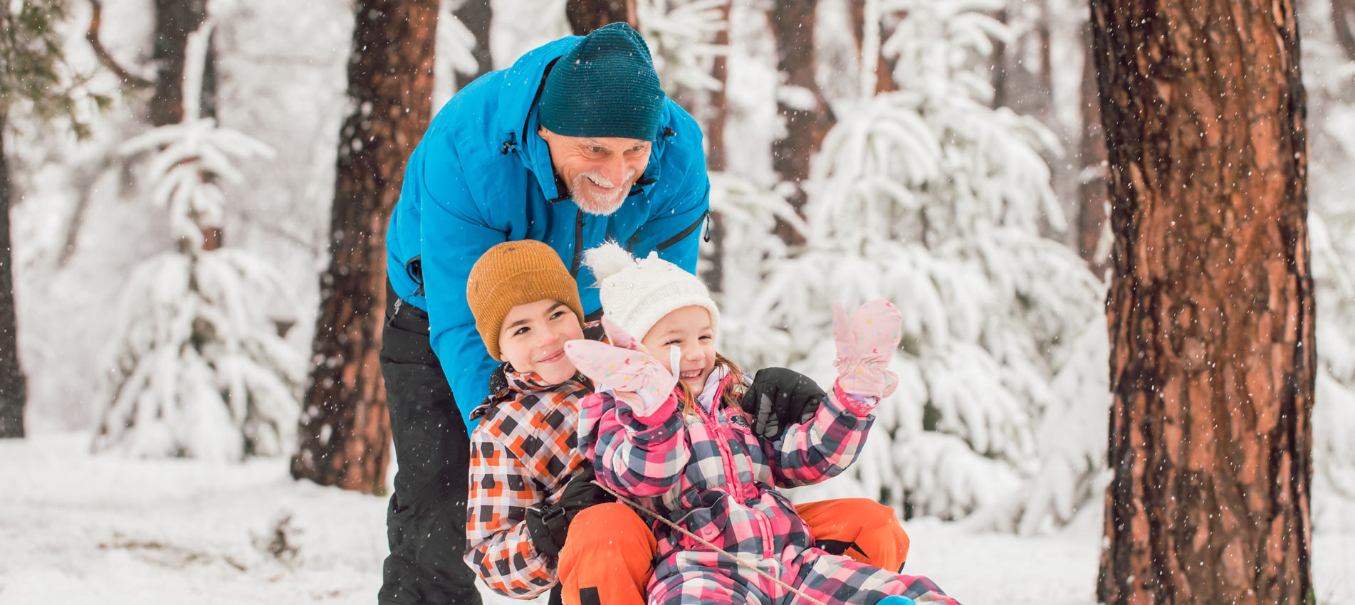 Children With Grandfather Having Fun On A Winter Day