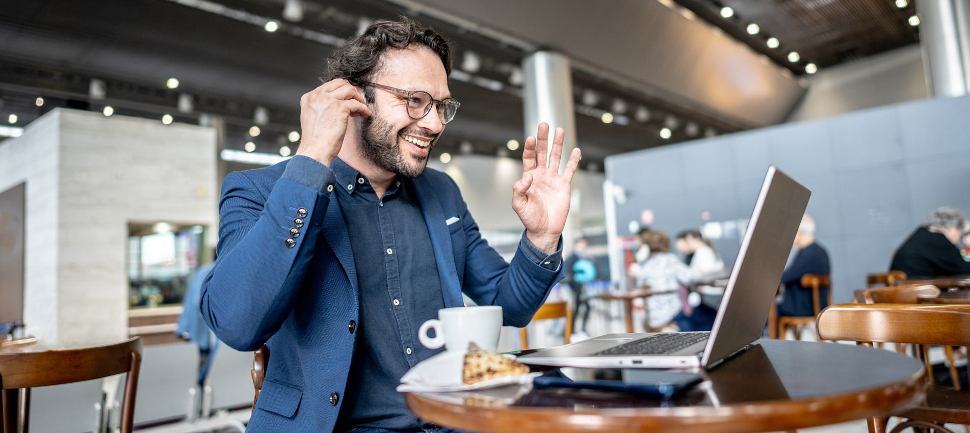 Businessman Doing A Video Call Using Laptop In Coffee Shop At Airport