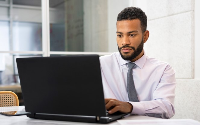 Businessman Working With Laptop While Sitting In Office