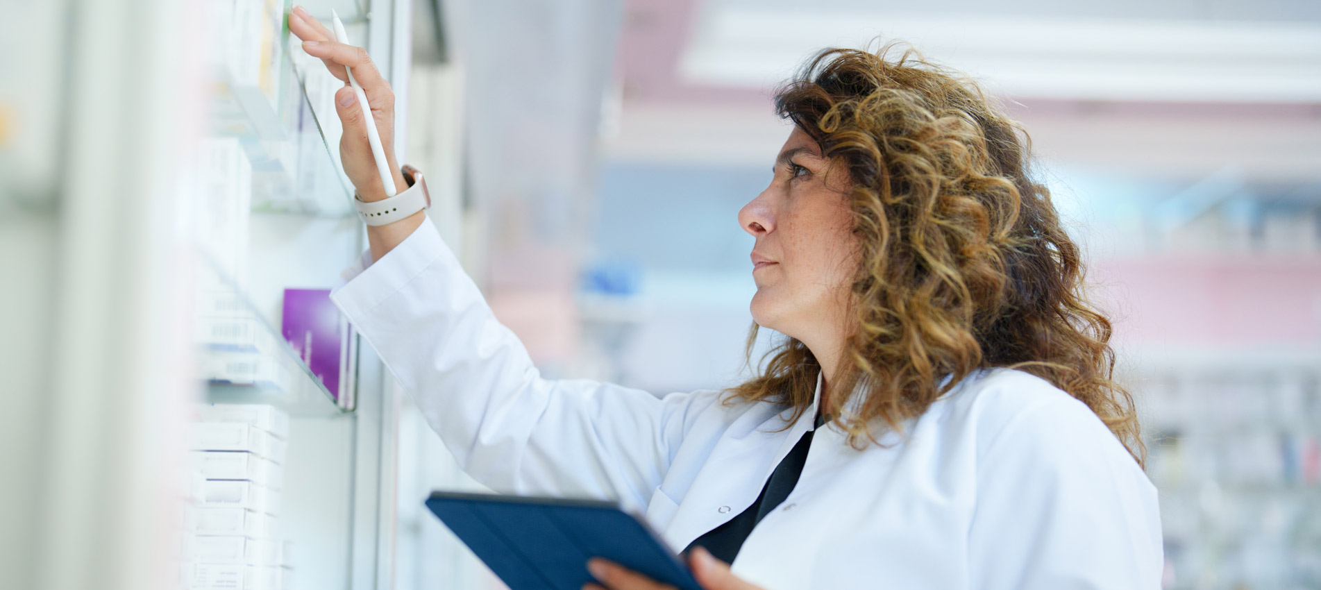 Pharmacist Using A Digital Tablet To Do Inventory In A Pharmacy