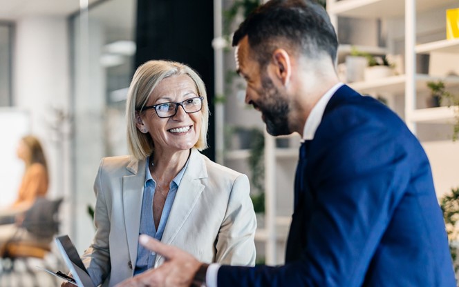 Senior Businesswoman And Male Colleague Discussing AI Technology