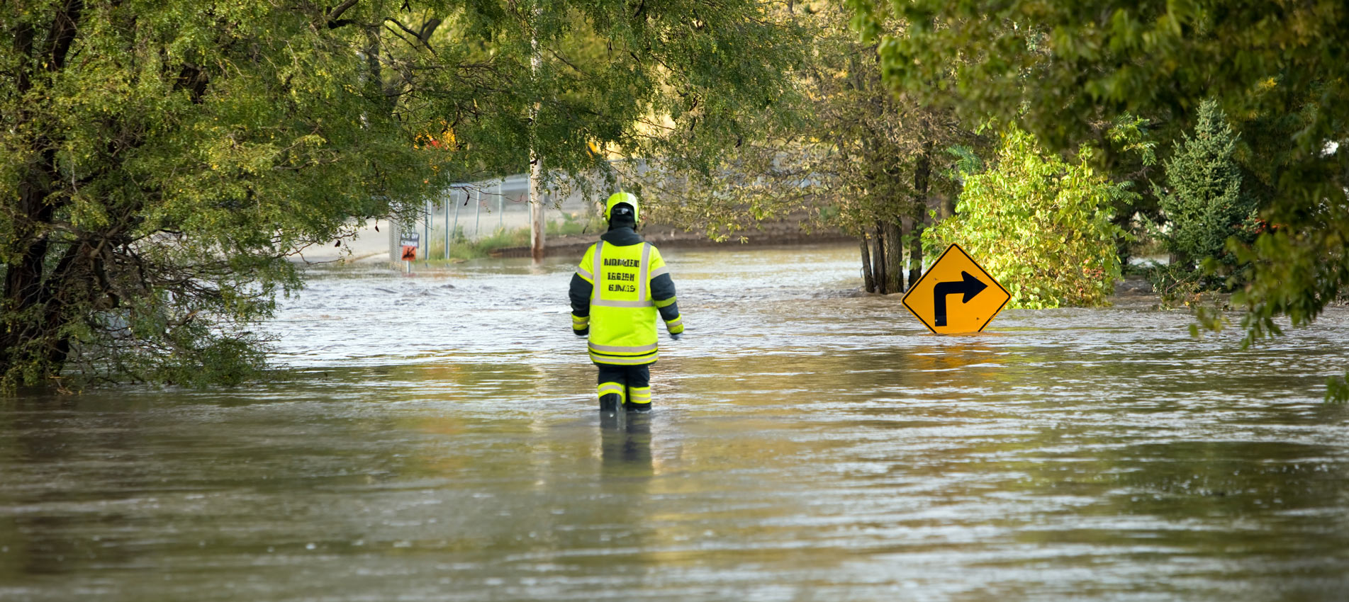 Emergency Personel Walking In A Flooded Street