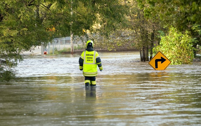 Emergency Personel Walking In A Flooded Street