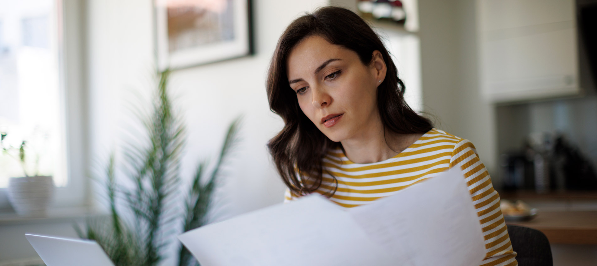 Young Woman Reading A Document At Home