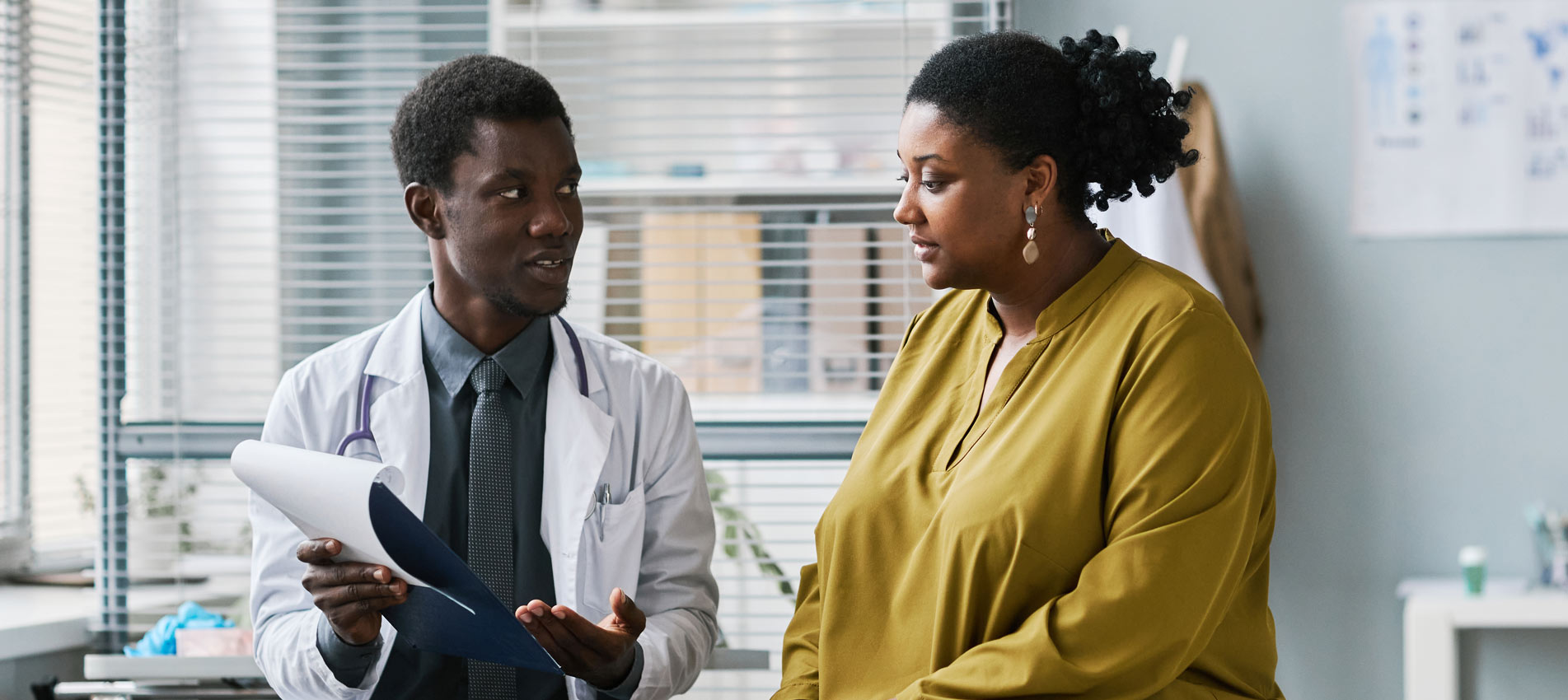 Overweight Black Woman Talking To Doctor In Medical Clinic