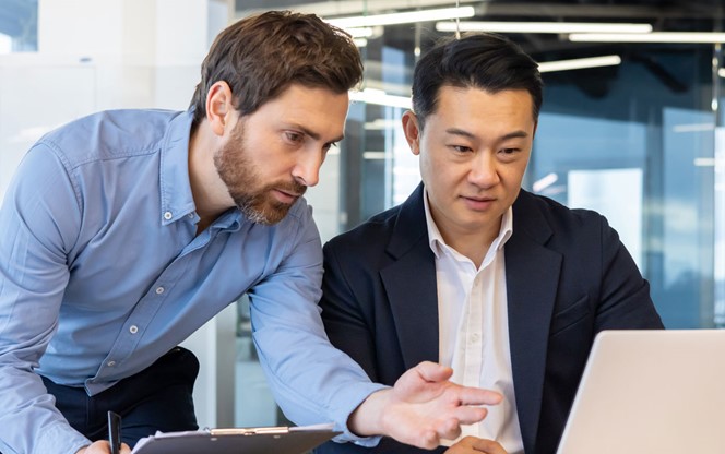 Two Business People At A Meeting Discussing Cybersecurity