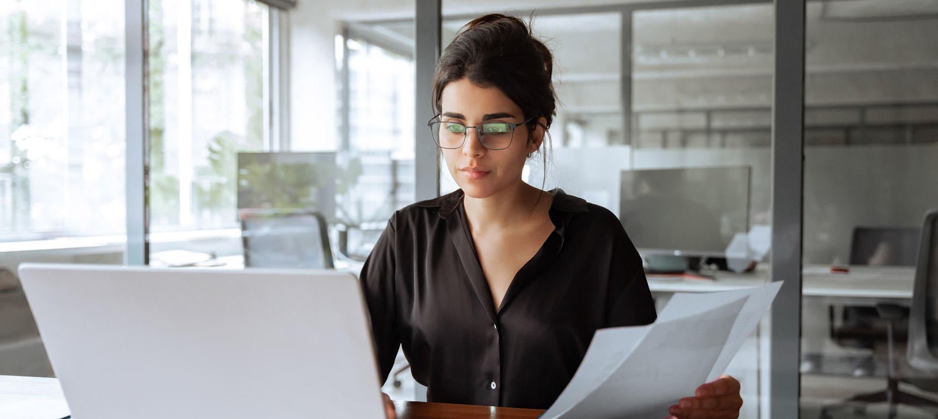Hispanic Young Business Woman Working On Laptop Computer Reading Financial Document Report In Office