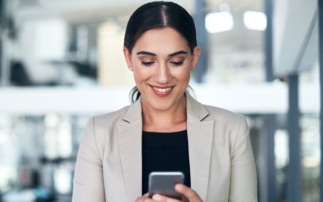 Businesswoman Using A Mobile Phone In A Modern Office