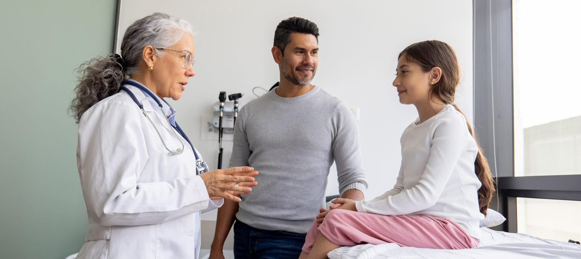 Doctor Explaining The Diagnosis To A Girl And Her Father In The Consultation Room