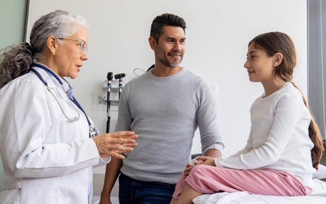 Doctor Explaining The Diagnosis To A Girl And Her Father In The Consultation Room