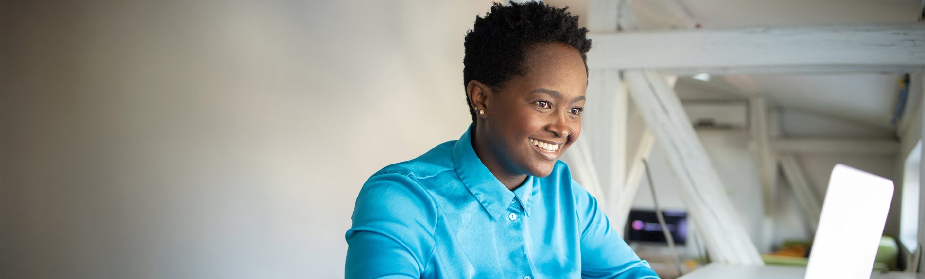 Young Woman Smiling And Working On A Laptop