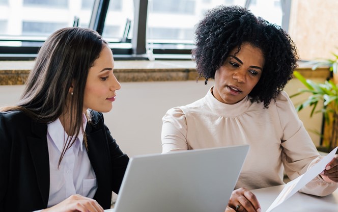 Two Female Colleagues Reviewing A Document At The Office