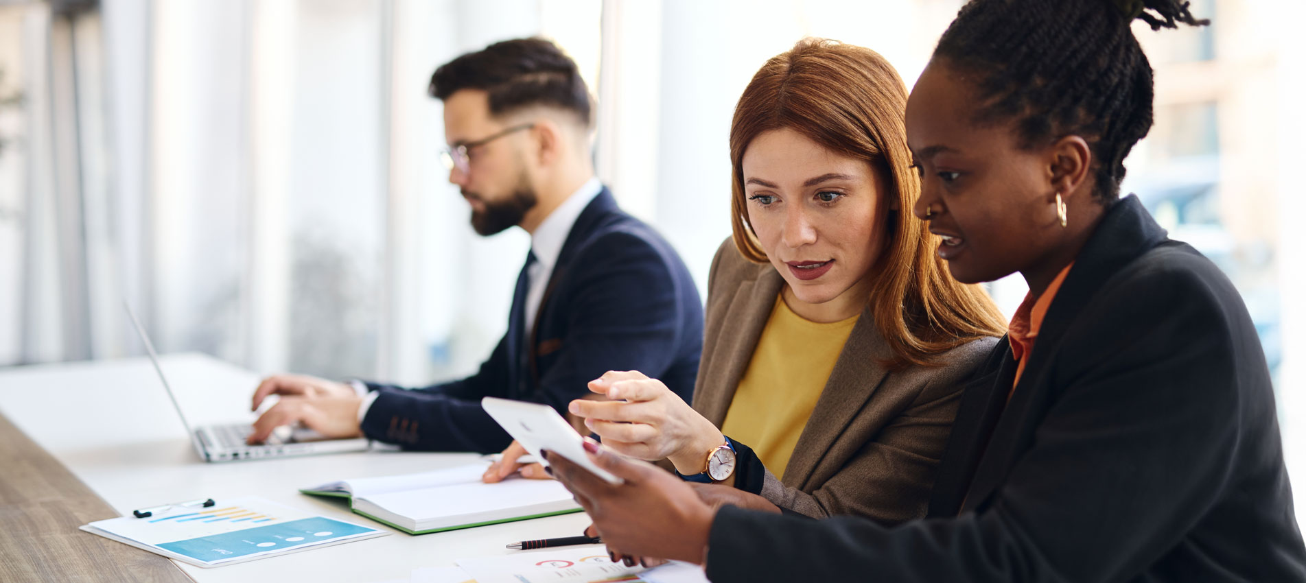 Businesswomen Using Tablet And Reviewing Data Charts