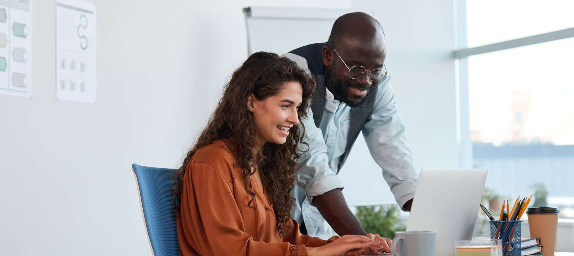 Two Colleagues Working Over A Project On A Laptop