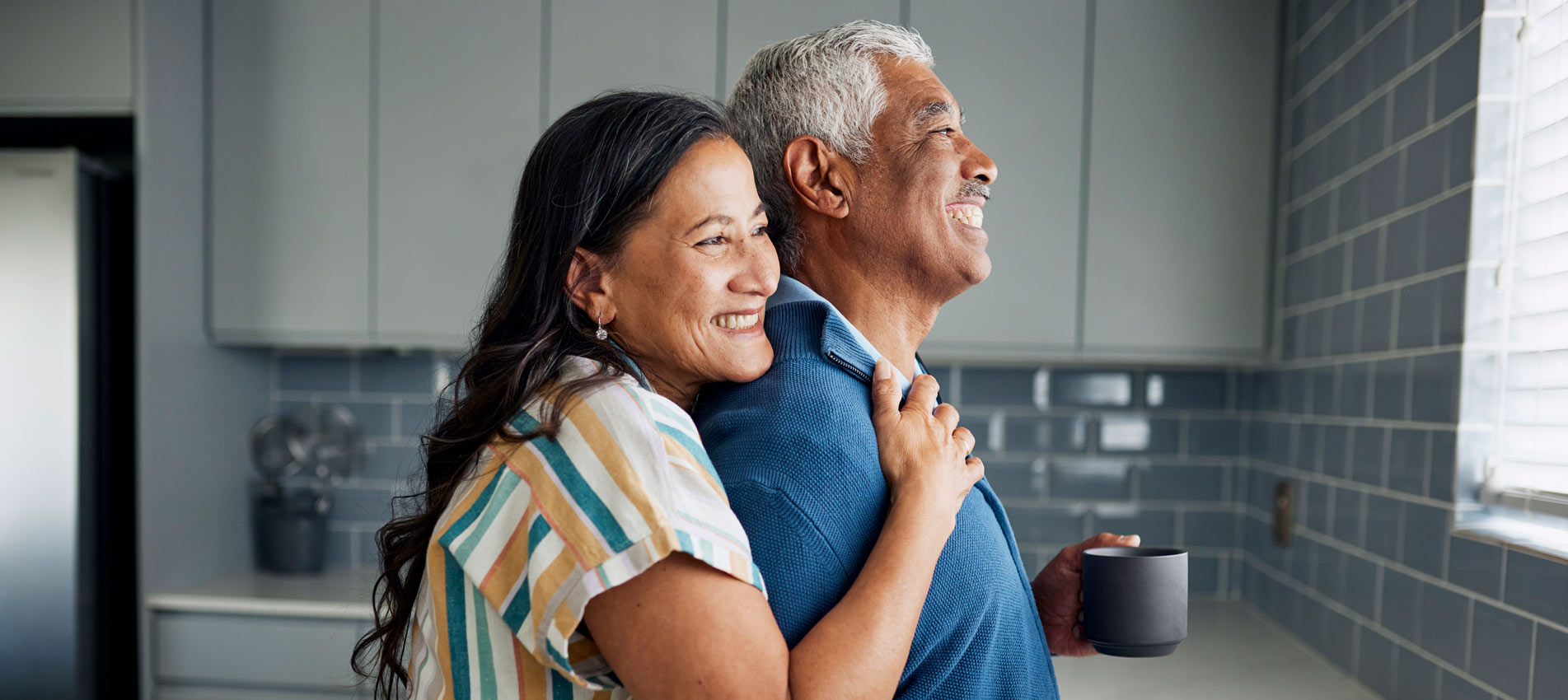 An Elderly Couple Is Drinking Coffee And Gazing Out The Kitchen Window