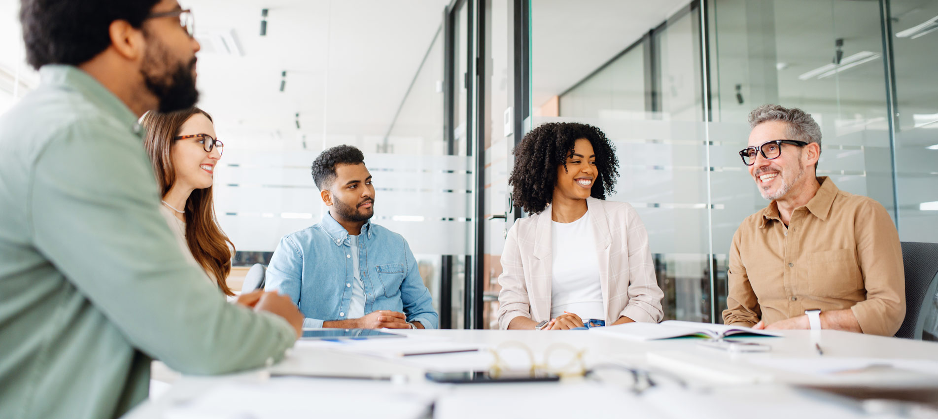 A Diverse Group Of Professionals Is Engaged In A Lively Discussion At The Office