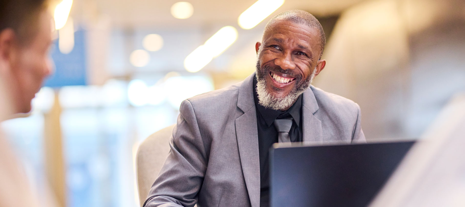 Smiling Businessman In A Suit Actively Engages In A Discussion