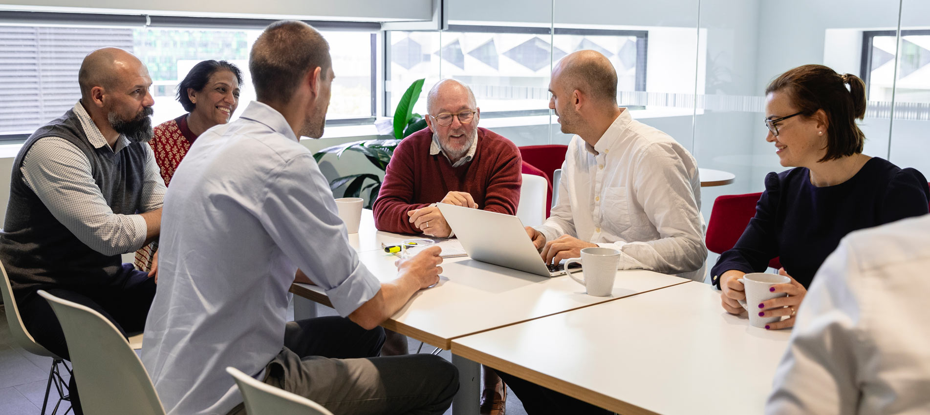 Diverse Group Of Professionals Sitting Around A Table In Discussion