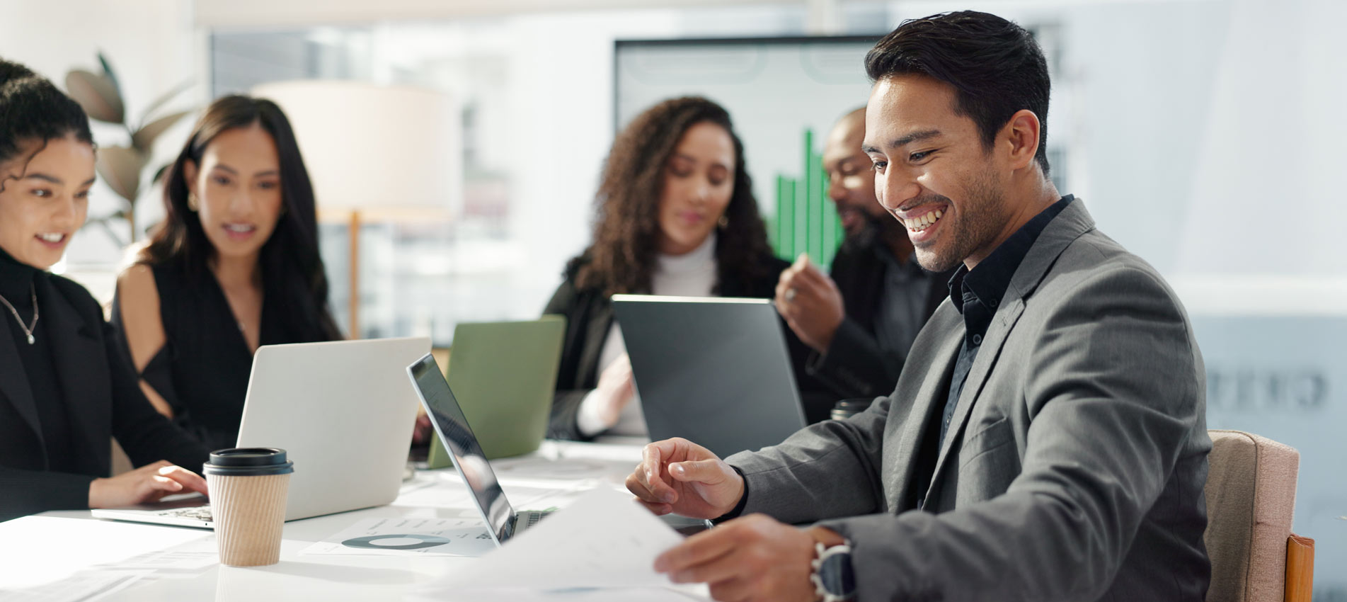 Businessman Smiling Analyzing The Market Graphs On A Laptop