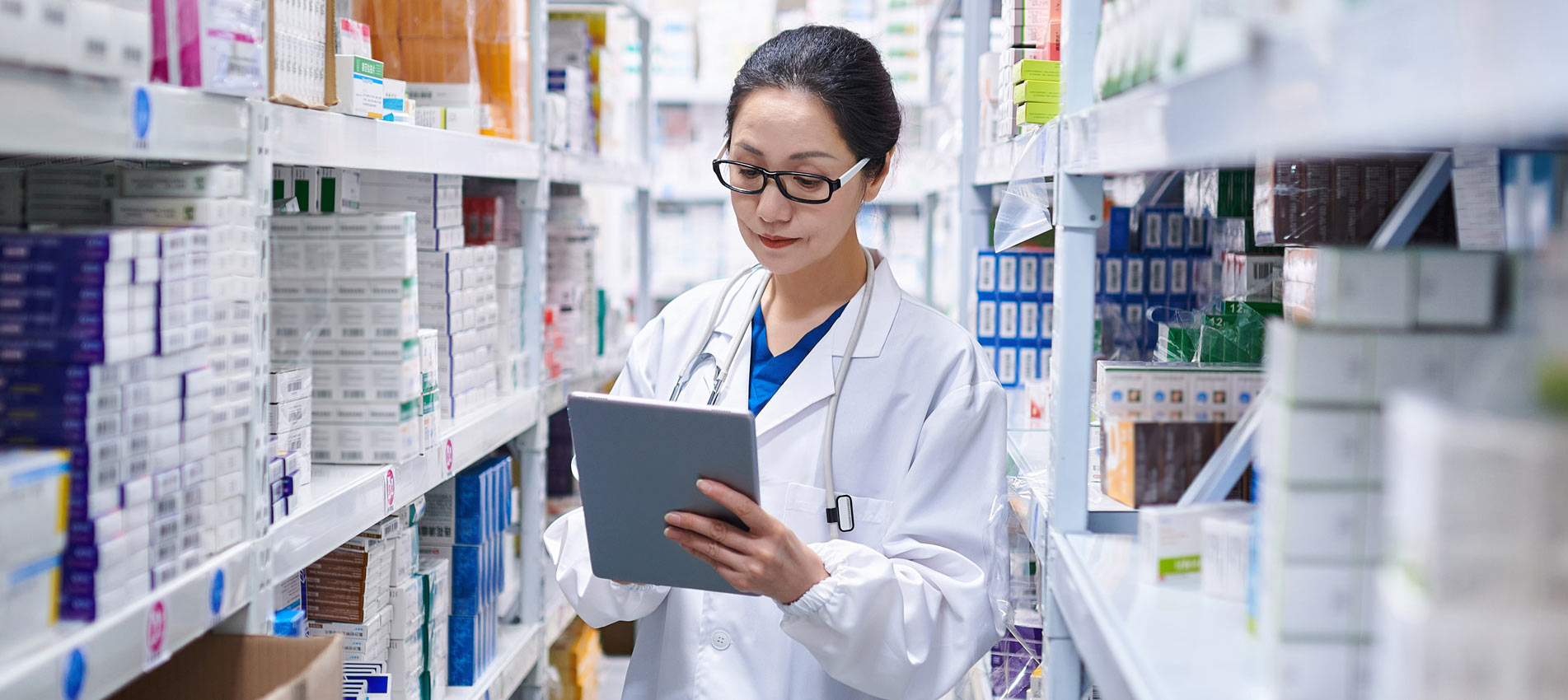 Asia Female Pharmacist Using Digital Tablet While Taking Inventory