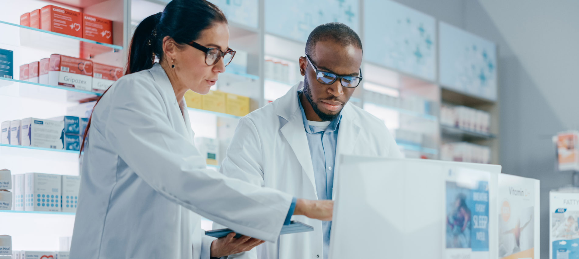 Black Male And Caucasian Female Pharmacists Working At The Pharmacy