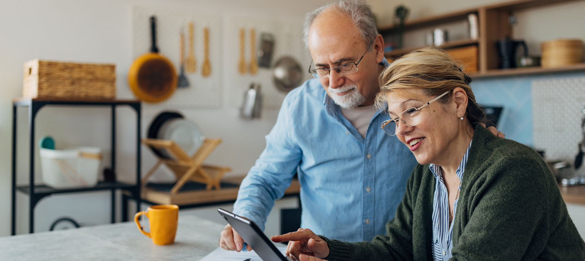 Senior Couple Managing Their Pension At Home Using Digital Tablet