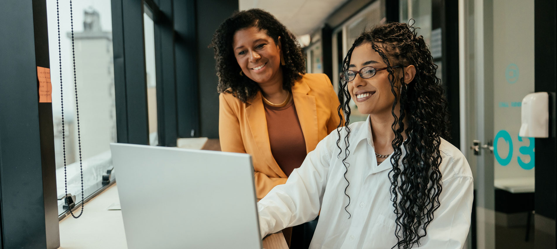 Two Businesswomen Working Together On A Laptop At The Office