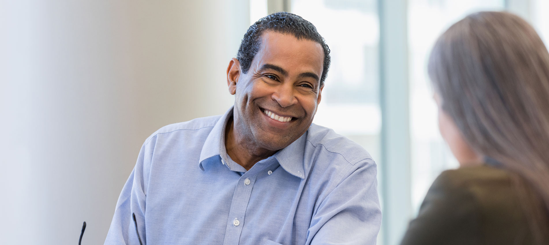 Mature Doctor Smiles While Discussing Documents With Female Administrator