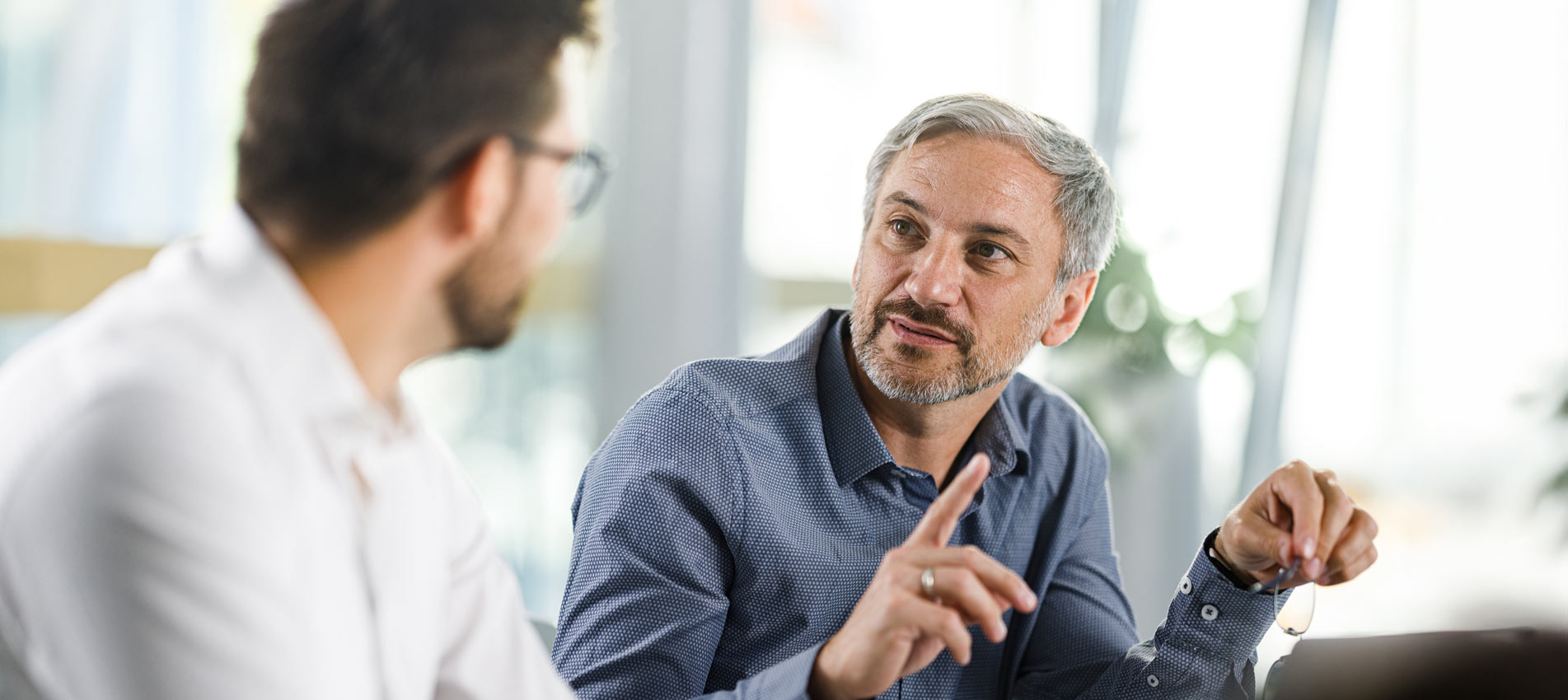 Mid Adult Businessman Having A Discussion With His Colleague In The Office