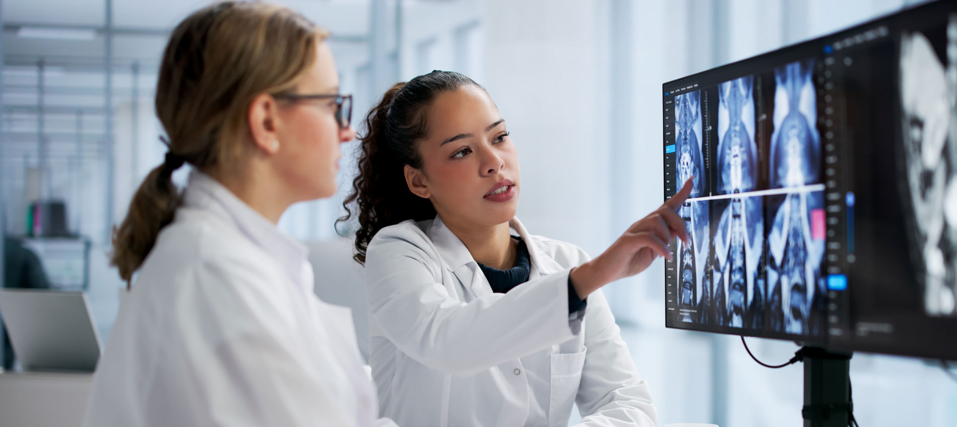 Female Radiologist Examining Spine MRI On Computer Screen