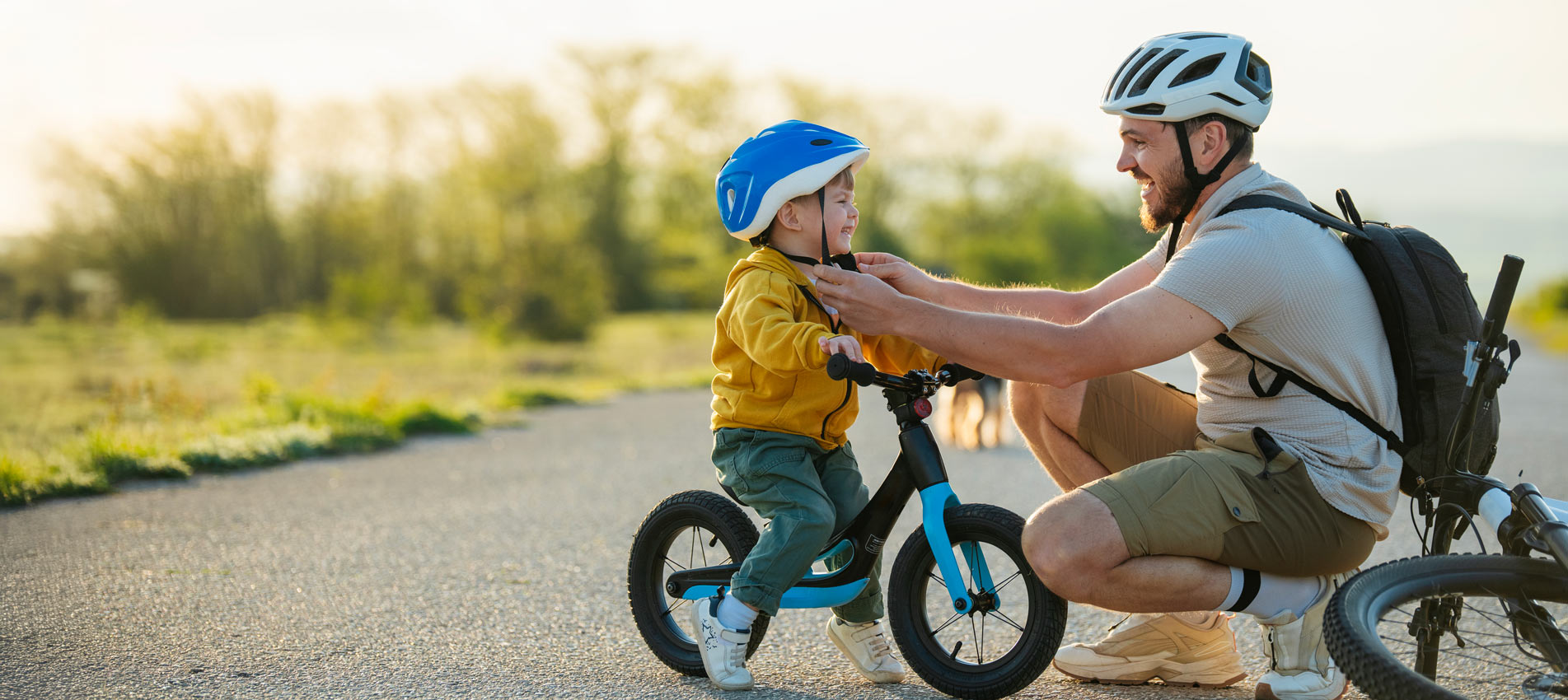 Father And Son Getting Ready For A Bike Ride On The Road